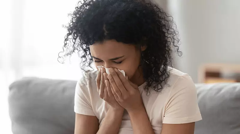 Woman blowing her nose